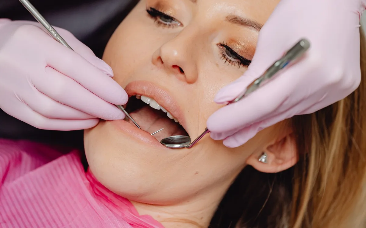 Pacientă la control stomatologic cu oglindă dentară